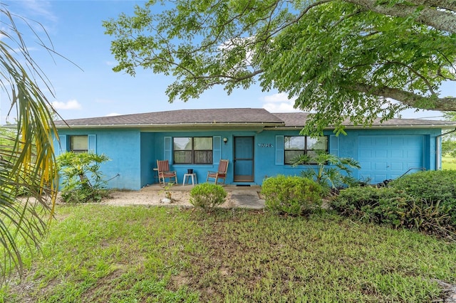 17128 SE 140th Ave, Weirsdale, FL 32195 - ranch-style home featuring stucco siding, a porch, a garage, and a front lawn