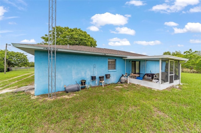 17128 SE 140th Ave, Weirsdale, FL 32195 - rear view of house featuring stucco siding, a sunroom, and a lawn