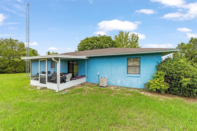 17128 SE 140th Ave, Weirsdale, FL 32195 - back of property featuring a sunroom, a lawn, central AC unit, and stucco siding