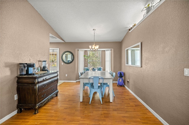 9 Bahia Trace Loop, Ocala, FL 34472 - dining area featuring a textured wall, healthy amount of natural light, a chandelier, light wood finished floors, and vaulted ceiling