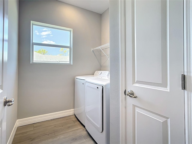 3018 Oceanside St, North Port, FL 34286 - laundry room featuring washer and clothes dryer, light wood-style flooring, and baseboards