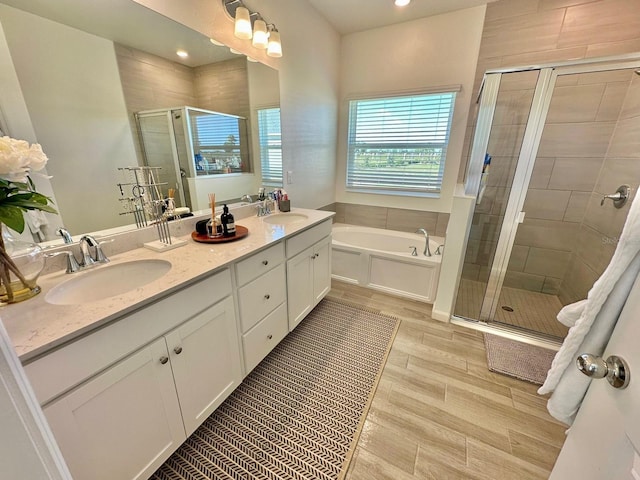 9253 SW 58th Cir, Ocala, FL 34476 - bathroom with a stall shower, a bath, double vanity, wood finished floors, and recessed lighting