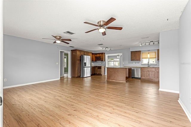 6989 SE 52nd Pl, Ocala, FL 34472 - unfurnished living room featuring ceiling fan, track lighting, light wood-type flooring, a sink, and a textured ceiling