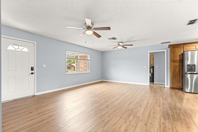 6989 SE 52nd Pl, Ocala, FL 34472 - unfurnished living room with light wood finished floors, ceiling fan, a textured ceiling, and baseboards