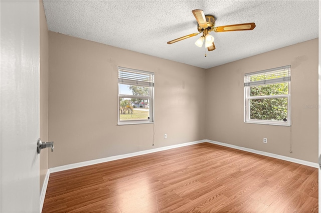 6989 SE 52nd Pl, Ocala, FL 34472 - empty room with plenty of natural light, light wood-style flooring, ceiling fan, baseboards, and a textured ceiling