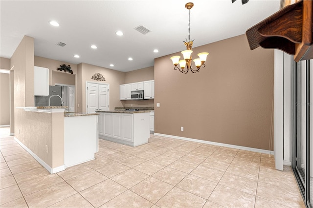 8961 SE 130th Loop, Summerfield, FL 34491 - kitchen with appliances with stainless steel finishes, a chandelier, light stone countertops, white cabinetry, and recessed lighting