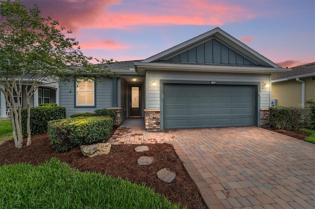 5651 NW 40th Pl, Ocala, FL 34482 - ranch-style home featuring board and batten siding, decorative driveway, an attached garage, and stone siding