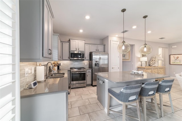5651 NW 40th Pl, Ocala, FL 34482 - kitchen featuring stainless steel appliances, gray cabinetry, a sink, backsplash, and light tile patterned floors