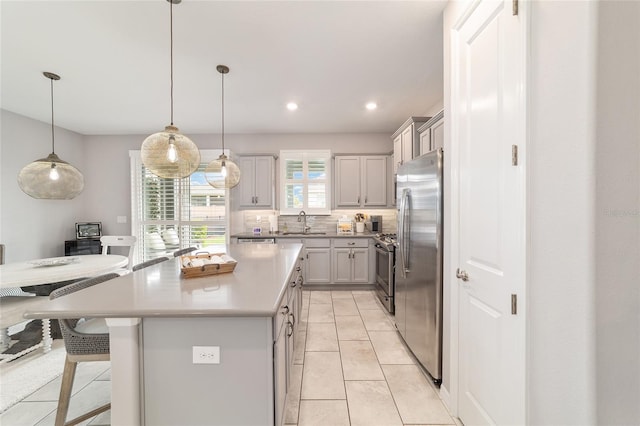 5651 NW 40th Pl, Ocala, FL 34482 - kitchen featuring appliances with stainless steel finishes, a kitchen bar, light countertops, a center island, and gray cabinetry