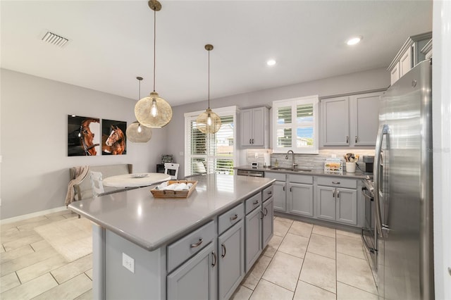 5651 NW 40th Pl, Ocala, FL 34482 - kitchen with a sink, gray cabinets, freestanding refrigerator, decorative backsplash, and recessed lighting