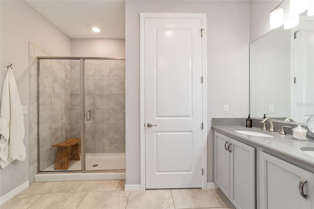 5651 NW 40th Pl, Ocala, FL 34482 - bathroom featuring a shower stall, double vanity, baseboards, and tile patterned flooring
