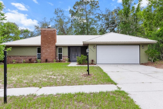 9606 N Caressa Way, Citrus Springs, FL 34434 - single story home with a chimney, an attached garage, concrete driveway, a front yard, and metal roof