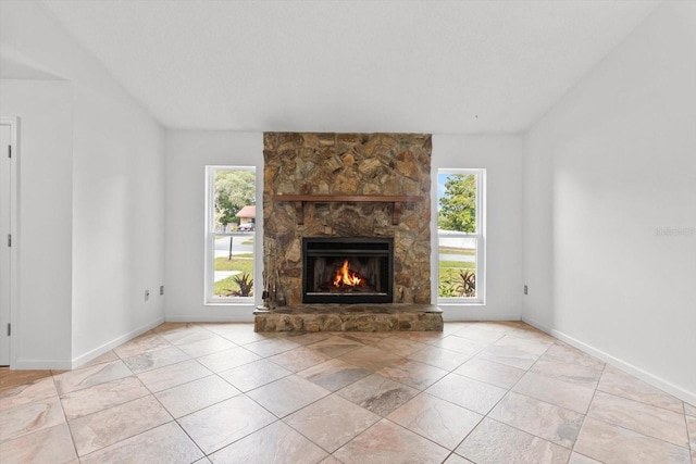 9606 N Caressa Way, Citrus Springs, FL 34434 - unfurnished living room with plenty of natural light, lofted ceiling, a stone fireplace, and baseboards