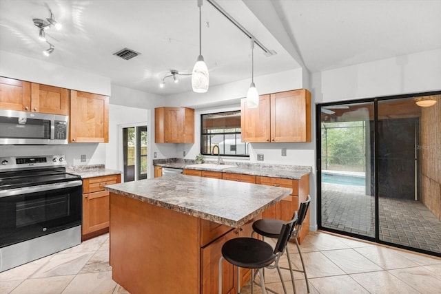 9606 N Caressa Way, Citrus Springs, FL 34434 - kitchen with stainless steel appliances, track lighting, a sink, a center island, and a kitchen breakfast bar