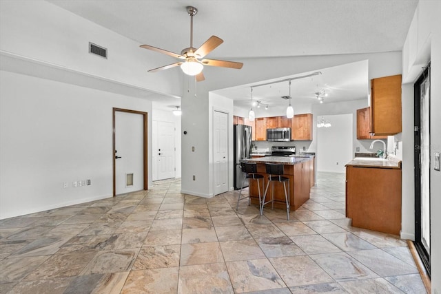 9606 N Caressa Way, Citrus Springs, FL 34434 - kitchen with appliances with stainless steel finishes, brown cabinetry, a ceiling fan, a center island, and track lighting
