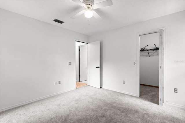 9606 N Caressa Way, Citrus Springs, FL 34434 - unfurnished bedroom with carpet, a walk in closet, baseboards, and a ceiling fan