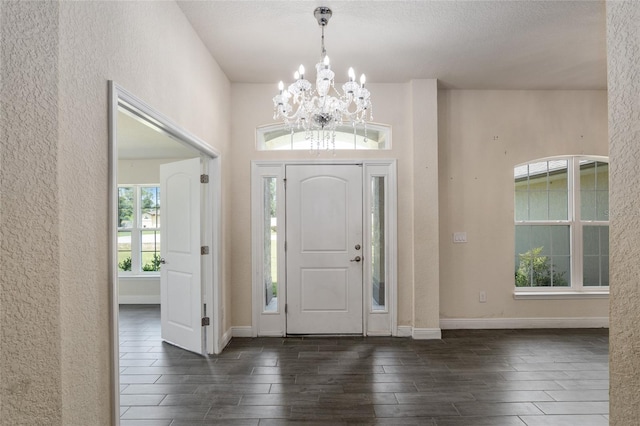 10910 SW 41st Ave, Ocala, FL 34476 - foyer entrance with a textured wall, wood finish floors, a chandelier, healthy amount of natural light, and baseboards