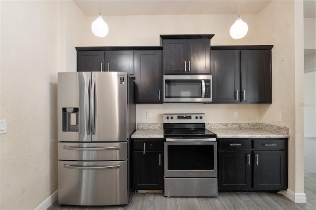 10910 SW 41st Ave, Ocala, FL 34476 - kitchen with appliances with stainless steel finishes, light wood-type flooring, baseboards, and decorative light fixtures