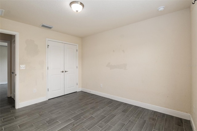 10910 SW 41st Ave, Ocala, FL 34476 - unfurnished bedroom featuring dark wood-style floors, baseboards, and a closet