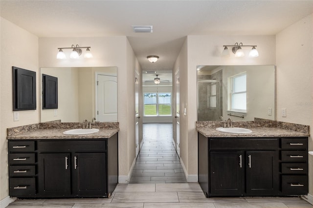 10910 SW 41st Ave, Ocala, FL 34476 - bathroom featuring a stall shower, two vanities, ceiling fan, and wood finish floors