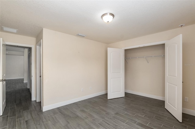 10910 SW 41st Ave, Ocala, FL 34476 - unfurnished bedroom with wood finish floors, baseboards, a closet, and a textured ceiling