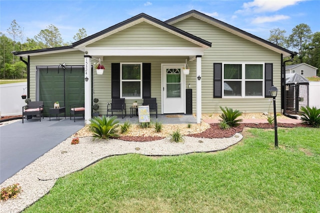 15324 SW 40th Place Rd, Ocala, FL 34481 - view of front of property with a porch, a garage, concrete driveway, and a front yard