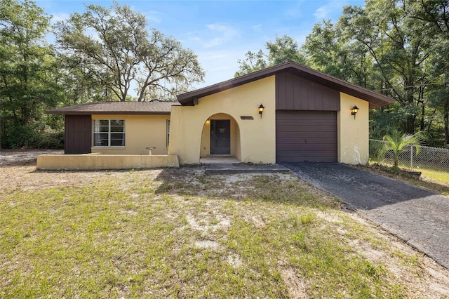 4467 SW Channel Heights Ct, Dunnellon, FL 34431 - mid-century inspired home featuring a garage, asphalt driveway, and stucco siding
