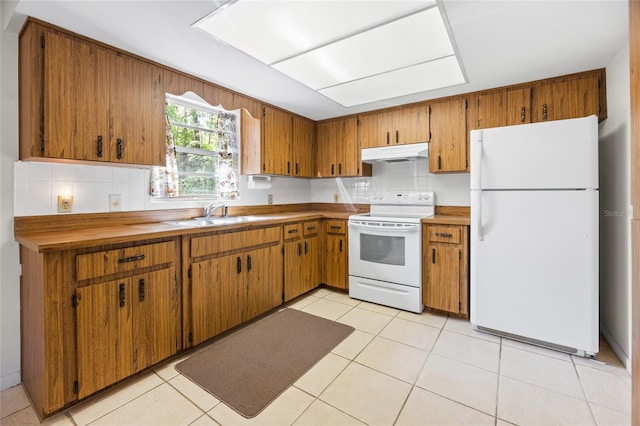 4467 SW Channel Heights Ct, Dunnellon, FL 34431 - kitchen with white appliances, under cabinet range hood, a sink, brown cabinetry, and backsplash