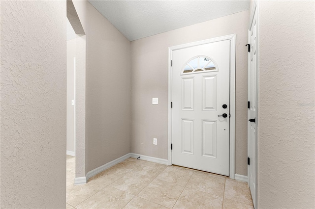 3445 SE 139th Ln, Summerfield, FL 34491 - entrance foyer featuring light tile patterned floors, a textured wall, baseboards, and lofted ceiling