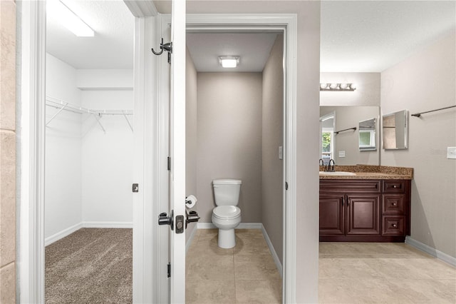 3445 SE 139th Ln, Summerfield, FL 34491 - bathroom featuring vanity, toilet, baseboards, a spacious closet, and tile patterned flooring