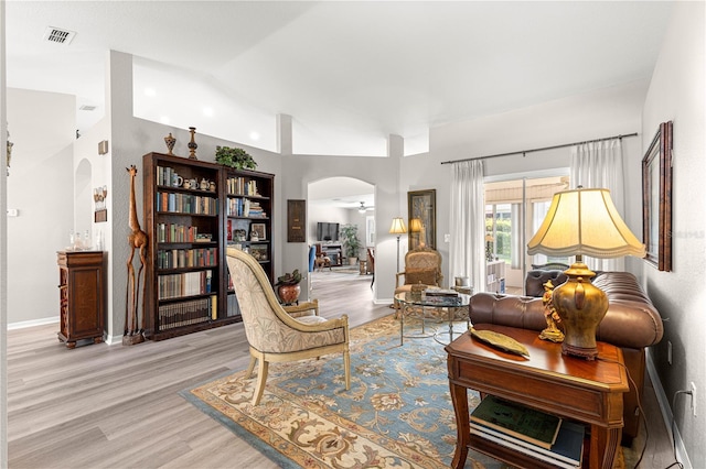 13715 SE 88th Ct, Summerfield, FL 34491 - living area featuring arched walkways, light wood finished floors, high vaulted ceiling, ceiling fan, and baseboards