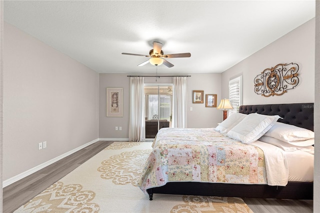 13715 SE 88th Ct, Summerfield, FL 34491 - bedroom featuring access to exterior, wood finished floors, baseboards, and ceiling fan