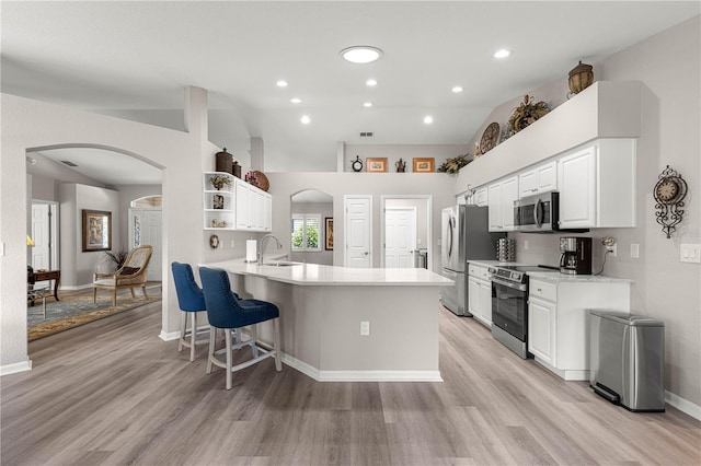 13715 SE 88th Ct, Summerfield, FL 34491 - kitchen with stainless steel appliances, arched walkways, light wood-style flooring, and recessed lighting