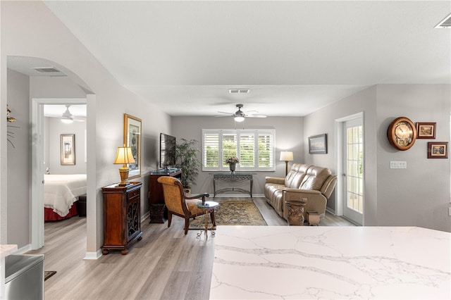 13715 SE 88th Ct, Summerfield, FL 34491 - living room featuring ceiling fan, light wood-style flooring, arched walkways, and baseboards