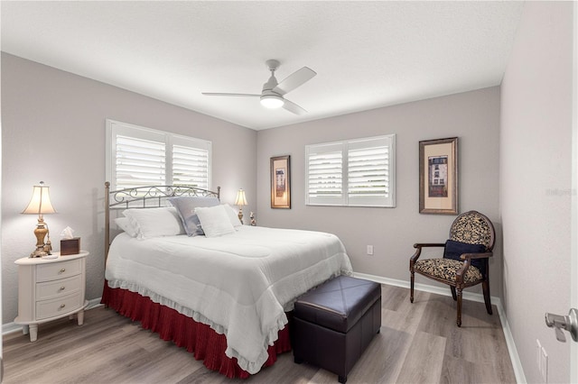 13715 SE 88th Ct, Summerfield, FL 34491 - bedroom with multiple windows, light wood finished floors, baseboards, and a ceiling fan