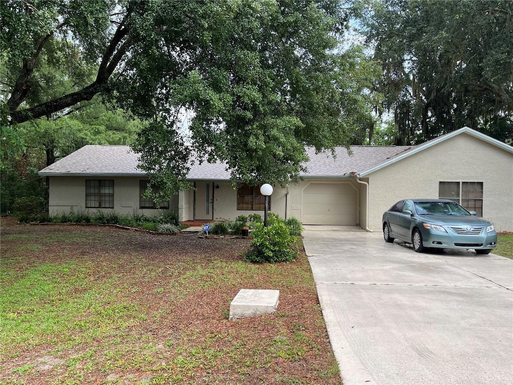 519 Spring Lake Rd, Ocala, FL 34472 - ranch-style house with driveway, a garage, stucco siding, and roof with shingles