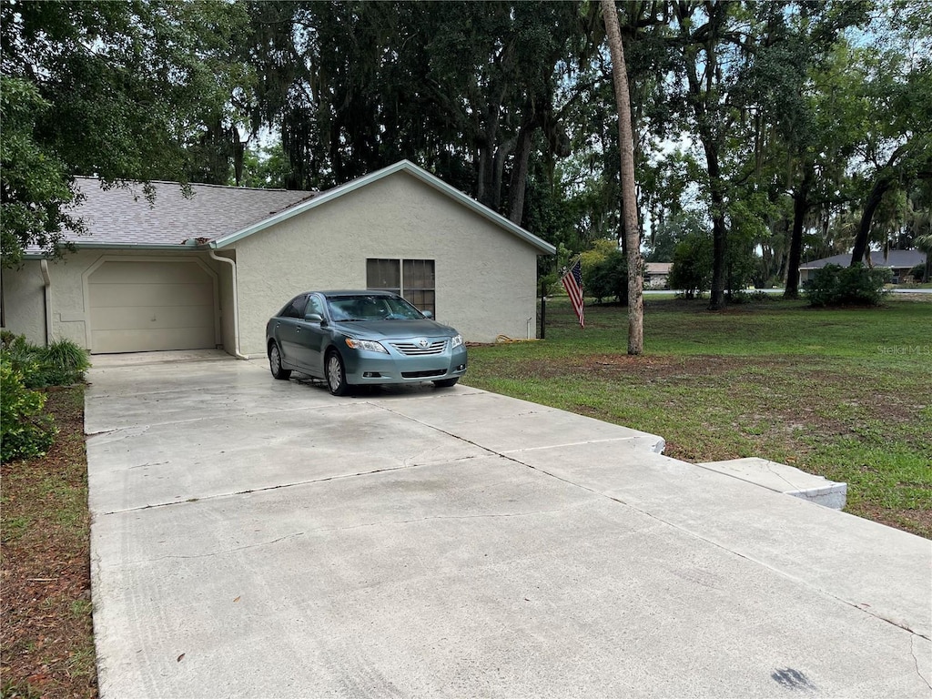 519 Spring Lake Rd, Ocala, FL 34472 - view of home's exterior featuring driveway, stucco siding, a garage, and a yard