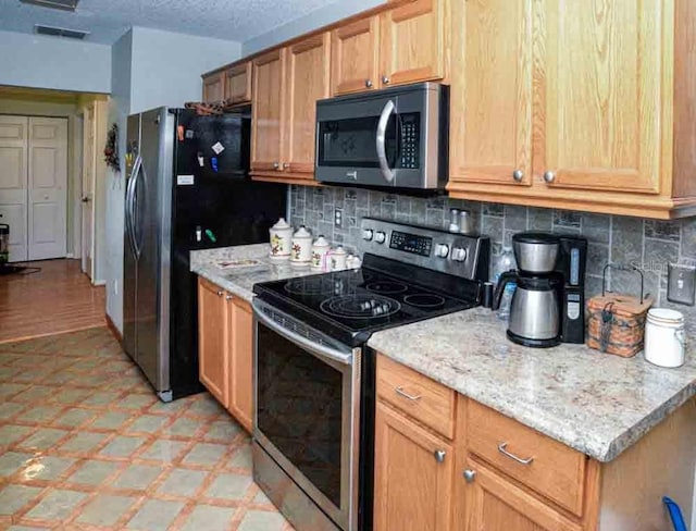 6190 SW 84th Pl, Ocala, FL 34476 - kitchen with appliances with stainless steel finishes, light floors, decorative backsplash, and light stone counters