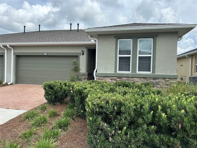 5255 NW 33rd Pl, Ocala, FL 34482 - view of front facade featuring decorative driveway, an attached garage, and stucco siding