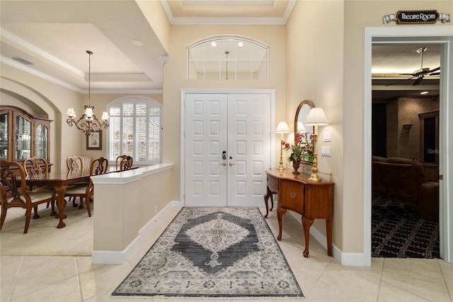 7915 SE 12th Cir, Ocala, FL 34480 - foyer with a tray ceiling, crown molding, a chandelier, light carpet, and light tile patterned floors