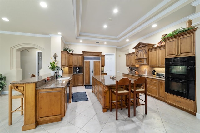 7915 SE 12th Cir, Ocala, FL 34480 - kitchen featuring paneled fridge, brown cabinets, a kitchen breakfast bar, decorative backsplash, and recessed lighting