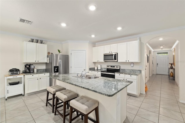 32 Hickory Course Loop, Ocala, FL 34472 - kitchen featuring stainless steel appliances, ornamental molding, light tile patterned floors, a sink, and a kitchen bar