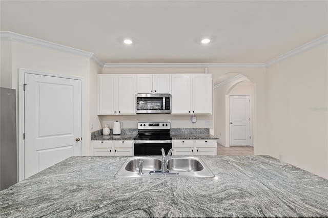 32 Hickory Course Loop, Ocala, FL 34472 - kitchen with stainless steel microwave, range with electric cooktop, a sink, crown molding, and white cabinetry