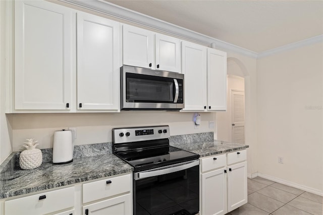 32 Hickory Course Loop, Ocala, FL 34472 - kitchen with stainless steel appliances, white cabinets, crown molding, arched walkways, and light tile patterned floors