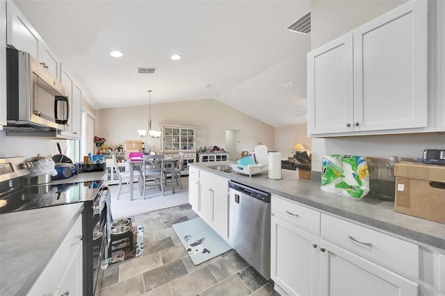 3418 SW 155th Pl, Ocala, FL 34473 - kitchen featuring appliances with stainless steel finishes, vaulted ceiling, white cabinetry, a chandelier, and decorative light fixtures