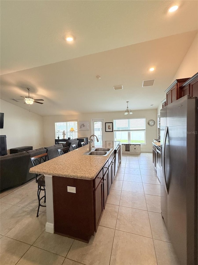 186 NW 44th St, Ocala, FL 34475 - kitchen with freestanding refrigerator, a breakfast bar, a center island with sink, recessed lighting, and light tile patterned floors
