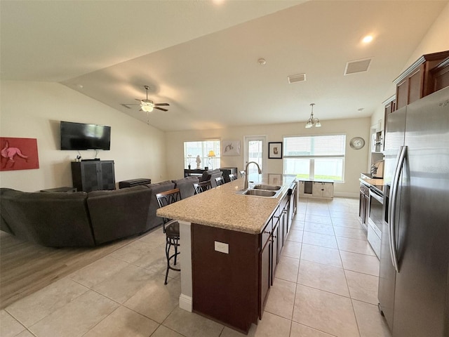 186 NW 44th St, Ocala, FL 34475 - kitchen with appliances with stainless steel finishes, a kitchen bar, a kitchen island with sink, healthy amount of natural light, and lofted ceiling