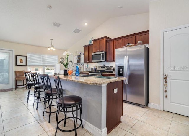 186 NW 44th St, Ocala, FL 34475 - kitchen with stainless steel appliances, lofted ceiling, light tile patterned floors, a breakfast bar, and tasteful backsplash