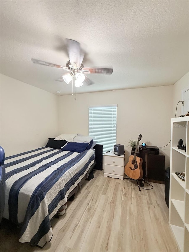 186 NW 44th St, Ocala, FL 34475 - bedroom with light wood-style flooring, a textured ceiling, and ceiling fan