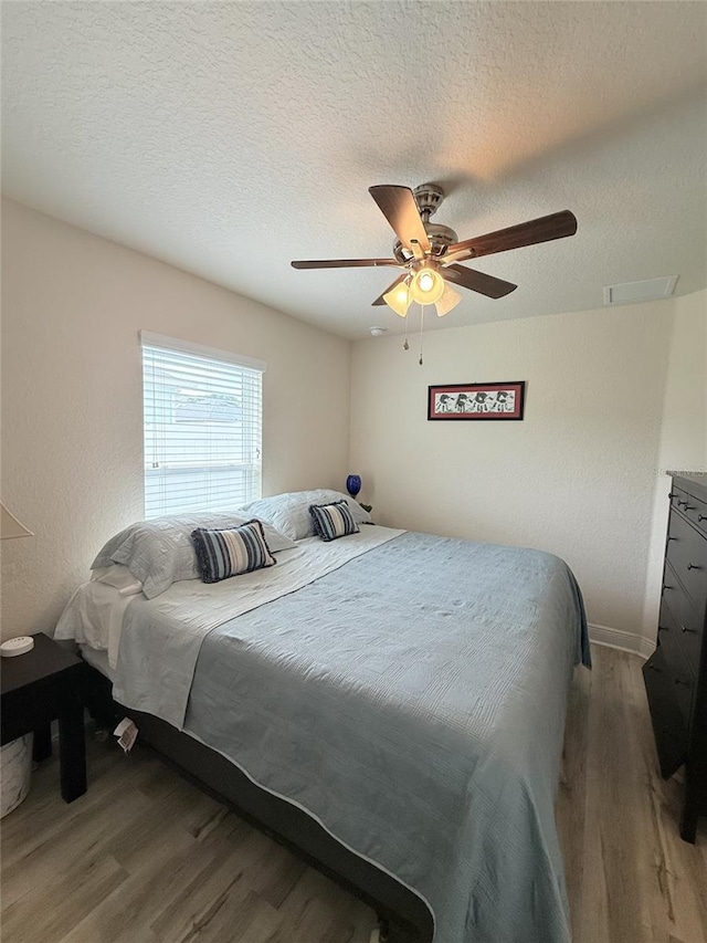 186 NW 44th St, Ocala, FL 34475 - bedroom featuring wood finished floors, a ceiling fan, and a textured ceiling